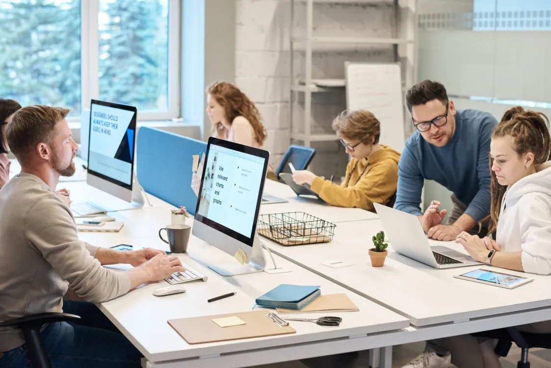 Team collaborating at workstations in a modern office